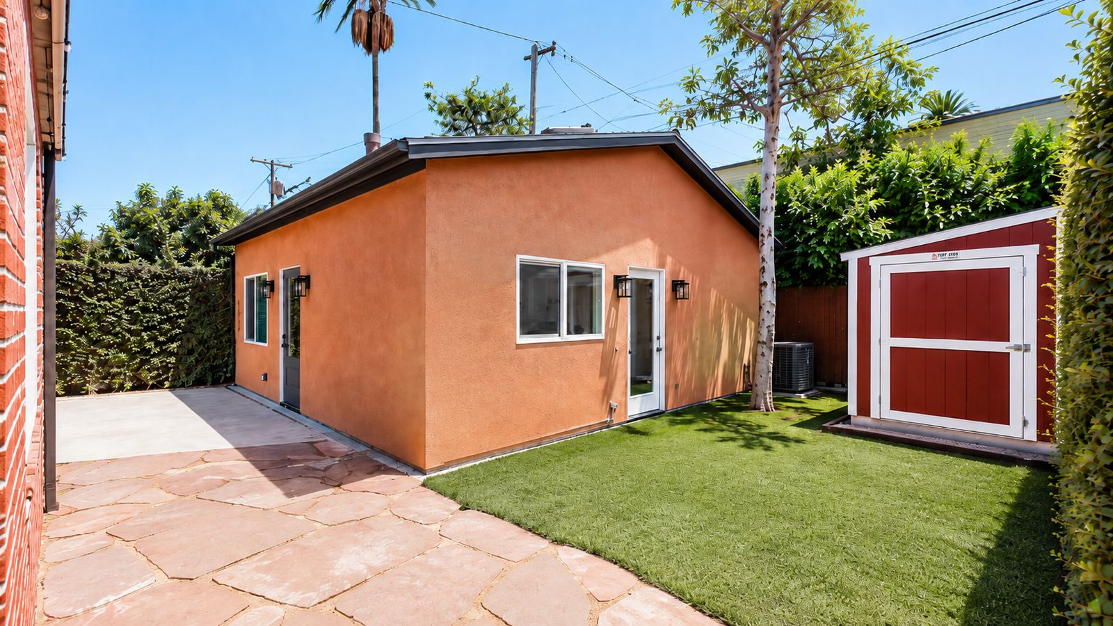 Angled exterior view with turf yard and storage shed