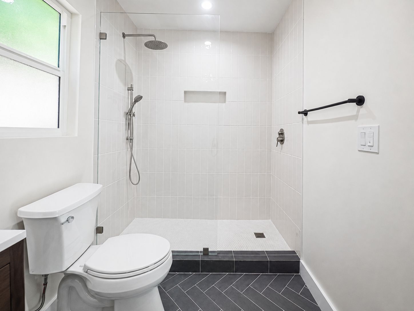 Second bathroom shower with herringbone tile and black hardware