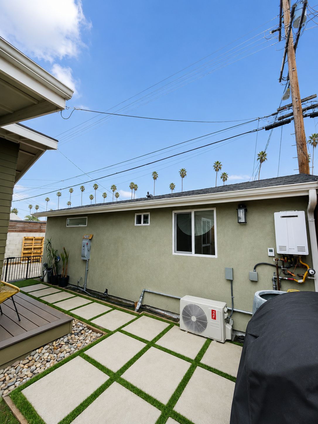 Exterior utility side showing tankless water heater and mini-split condenser
