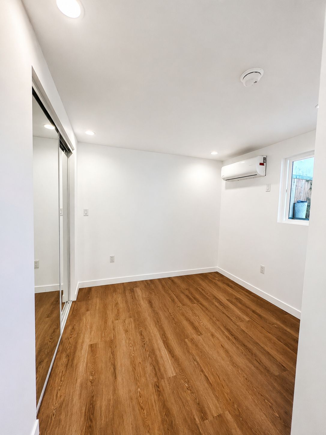 Finished bedroom with mirrored closet doors