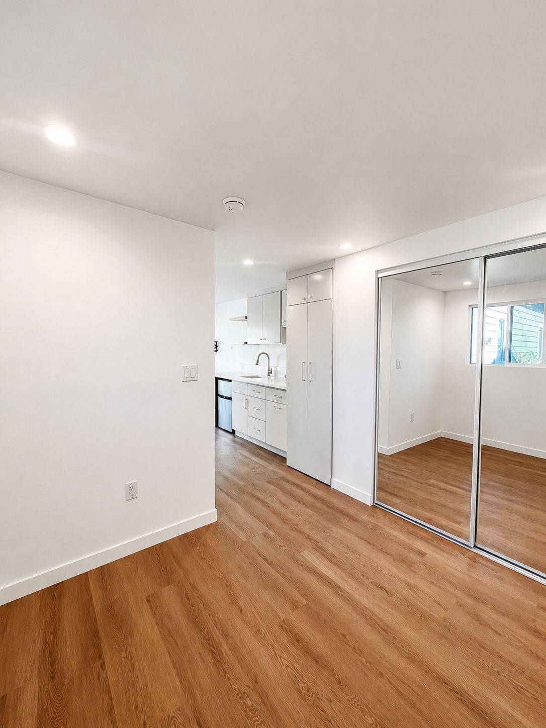 Hallway with mirrored closet and view toward the kitchen