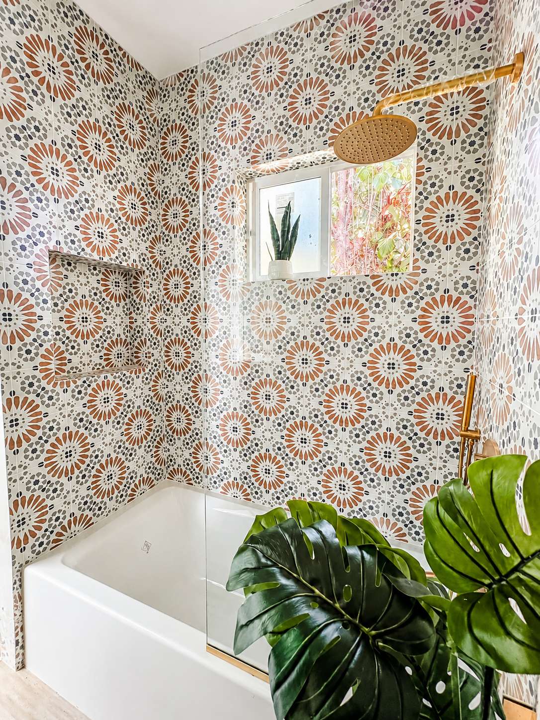Bathroom shower with colorful Moroccan-pattern tile and brass fixtures