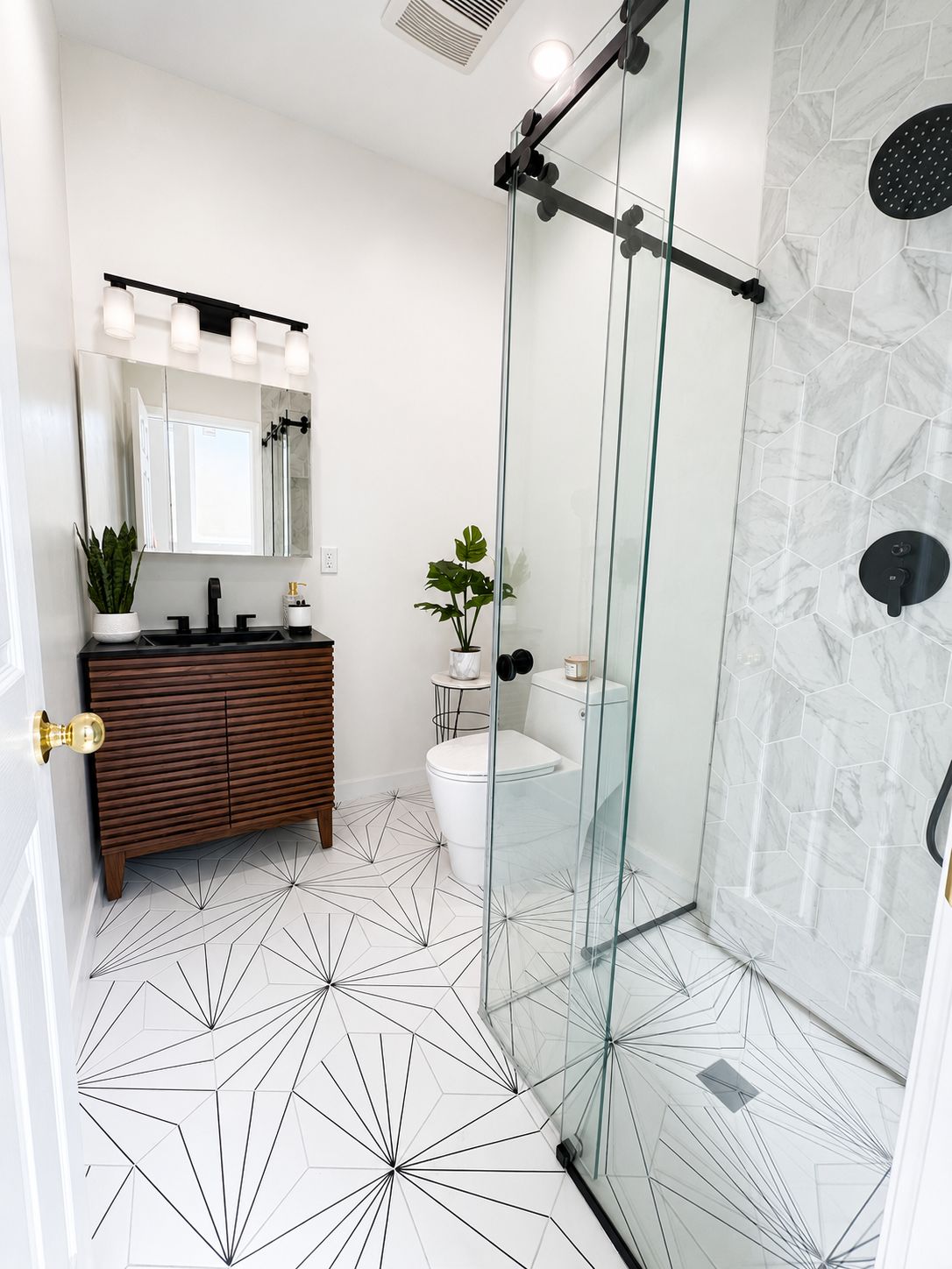 Bathroom shower with marble hexagon tile and black hardware