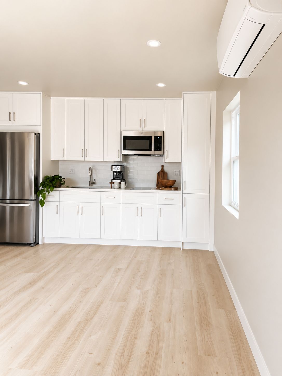 Kitchen with white shaker cabinetry and stainless refrigerator