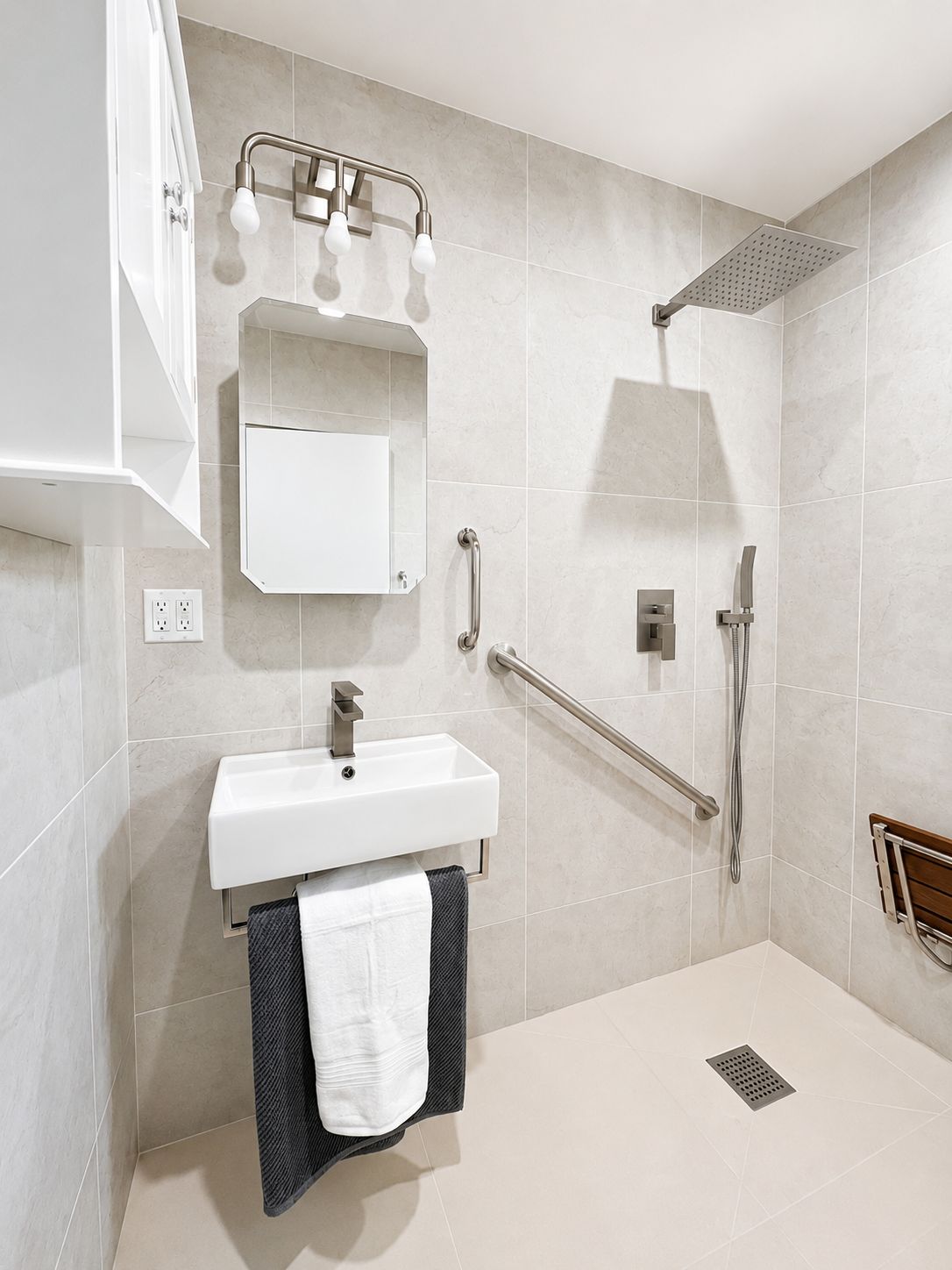 Accessible shower with fold-down bench and handheld sprayer