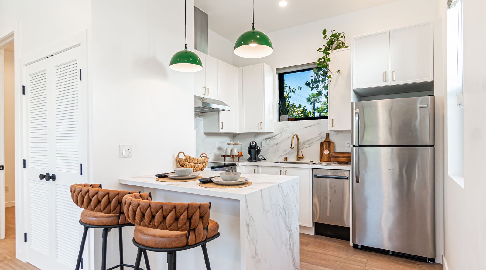 Kitchen with island seating and green pendant lights