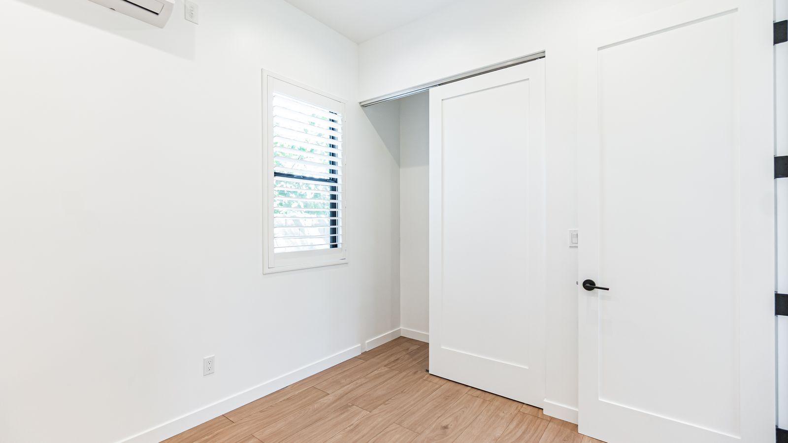 Bedroom with mini-split AC and sliding closet door
