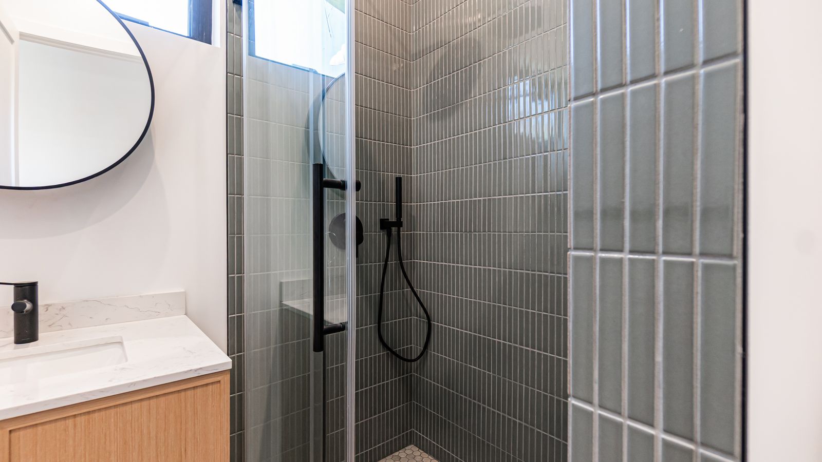 Tiled walk-in shower with black fixtures