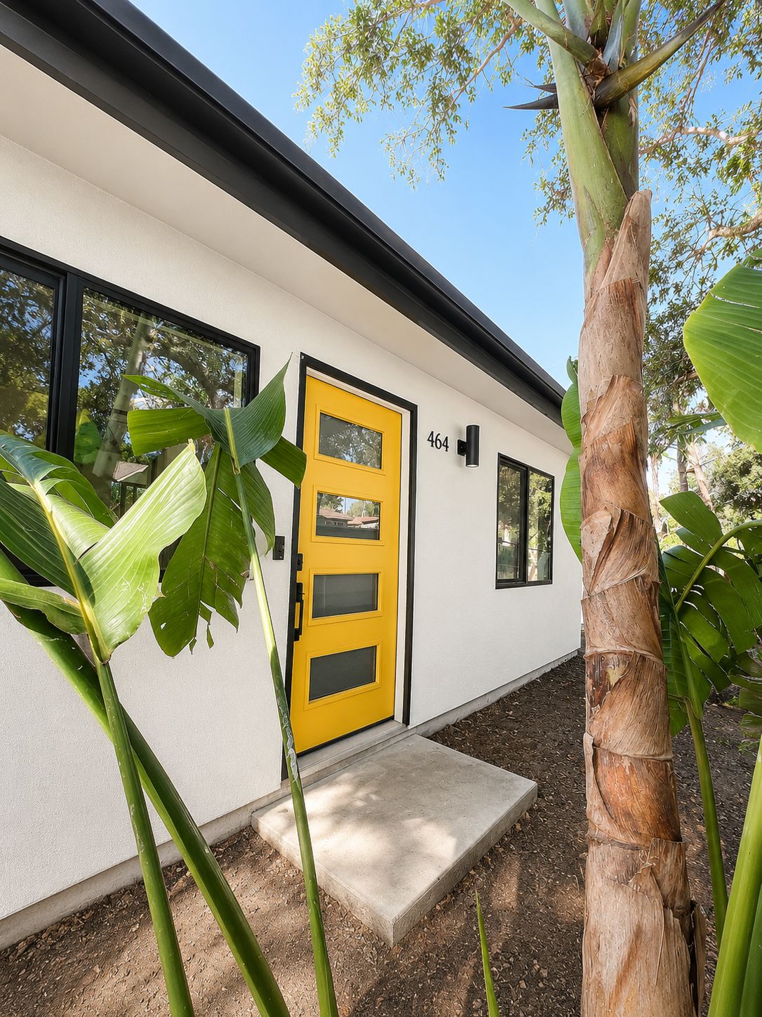 Front entry with yellow door and address numbers