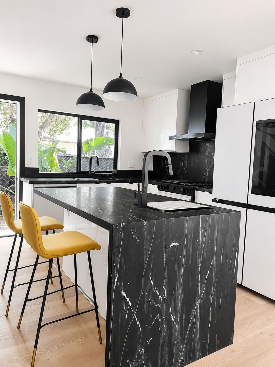 Kitchen island with yellow bar stools and pendant lighting