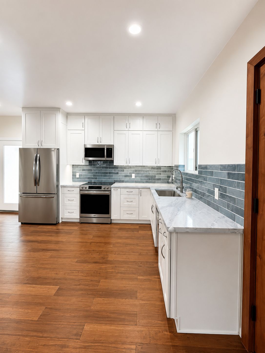Kitchen view toward the entry with wood front door
