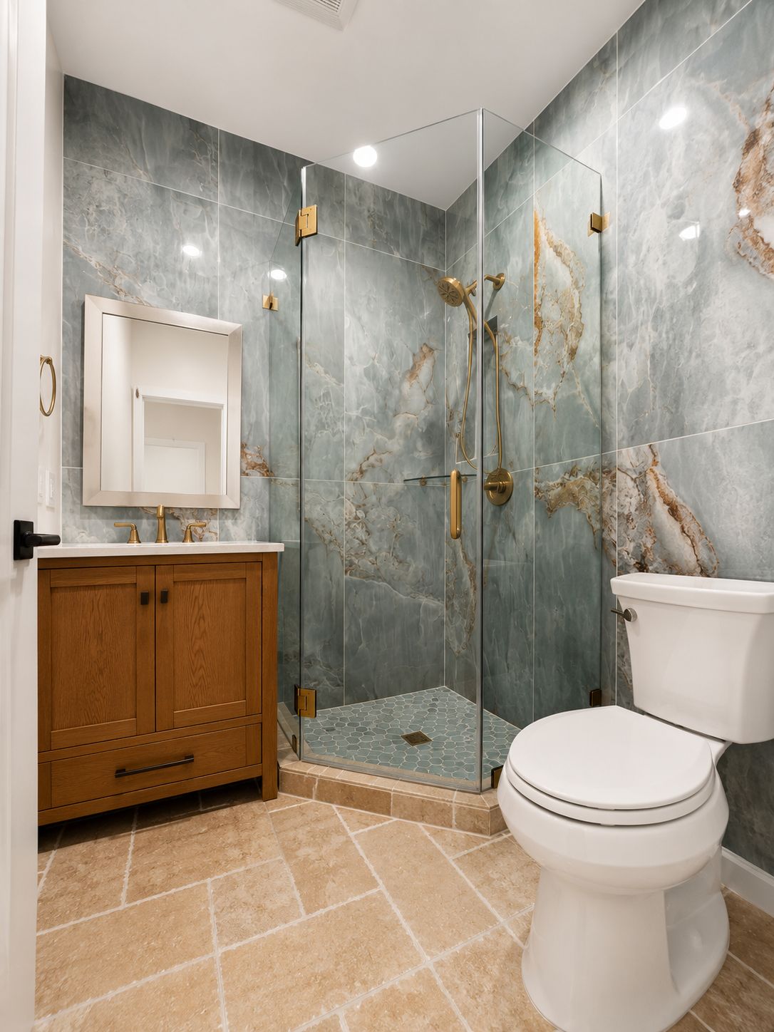 Bathroom shower with green marble tile and brass hardware