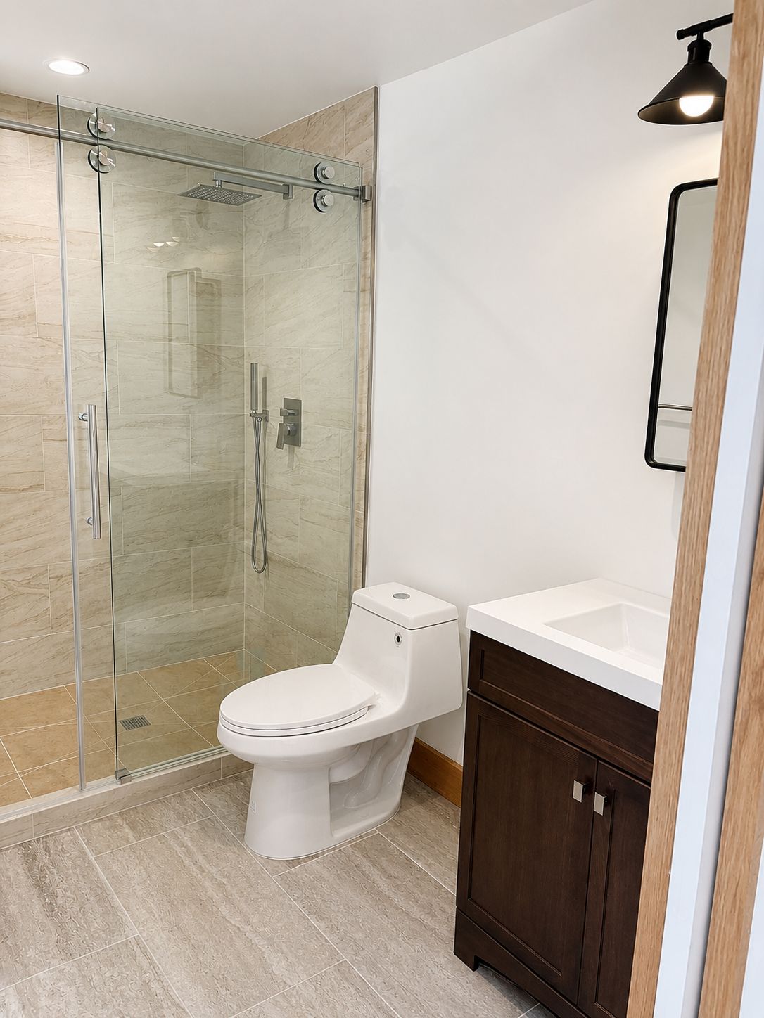 Finished bathroom with glass shower and dark wood vanity