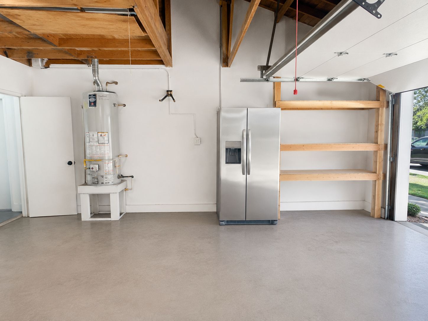 Garage interior before conversion with water heater and shelving